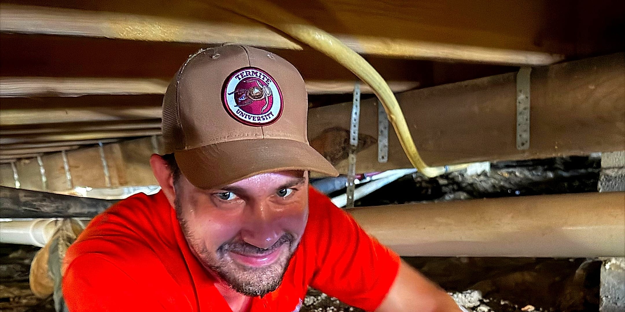 Josh Henderson, a Parker's Pest Management technician, working termites in a crawl space under a Pine Belt home