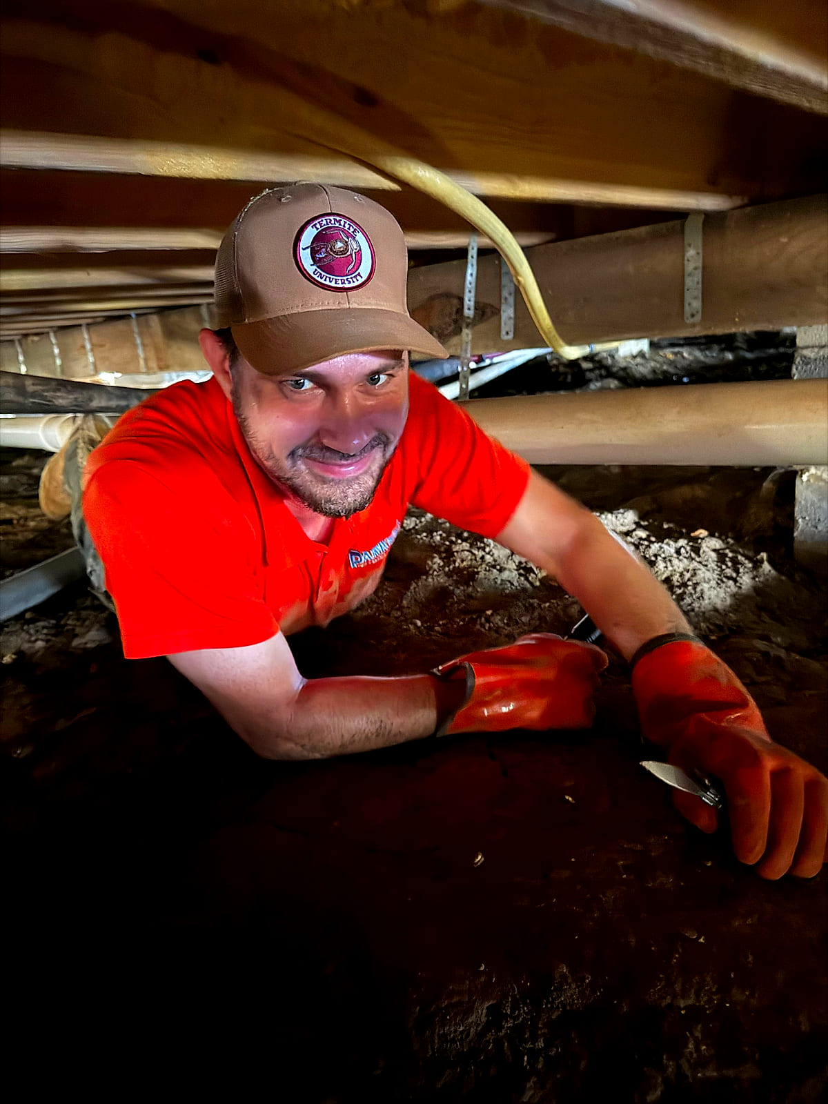 Josh Henderson, a Parker's Pest Management technician, working termites in a crawl space under a Pine Belt home