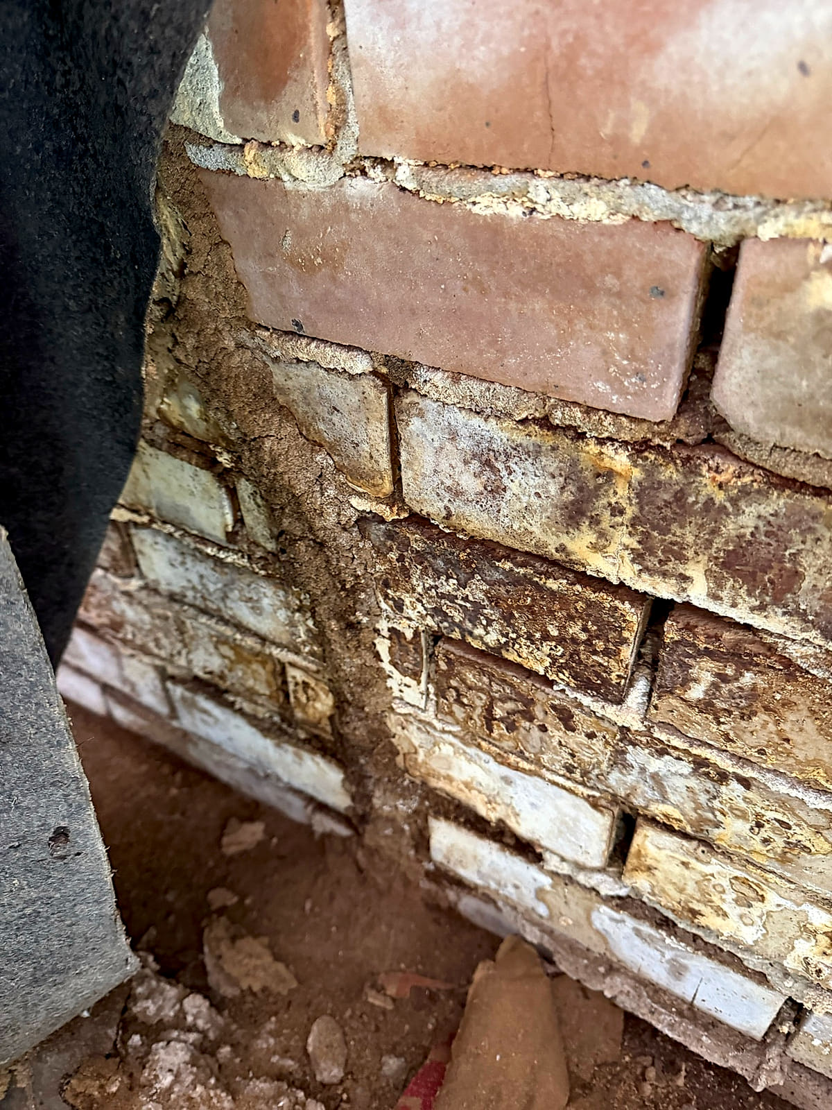 Mud tubes on brick beside a foundation vent