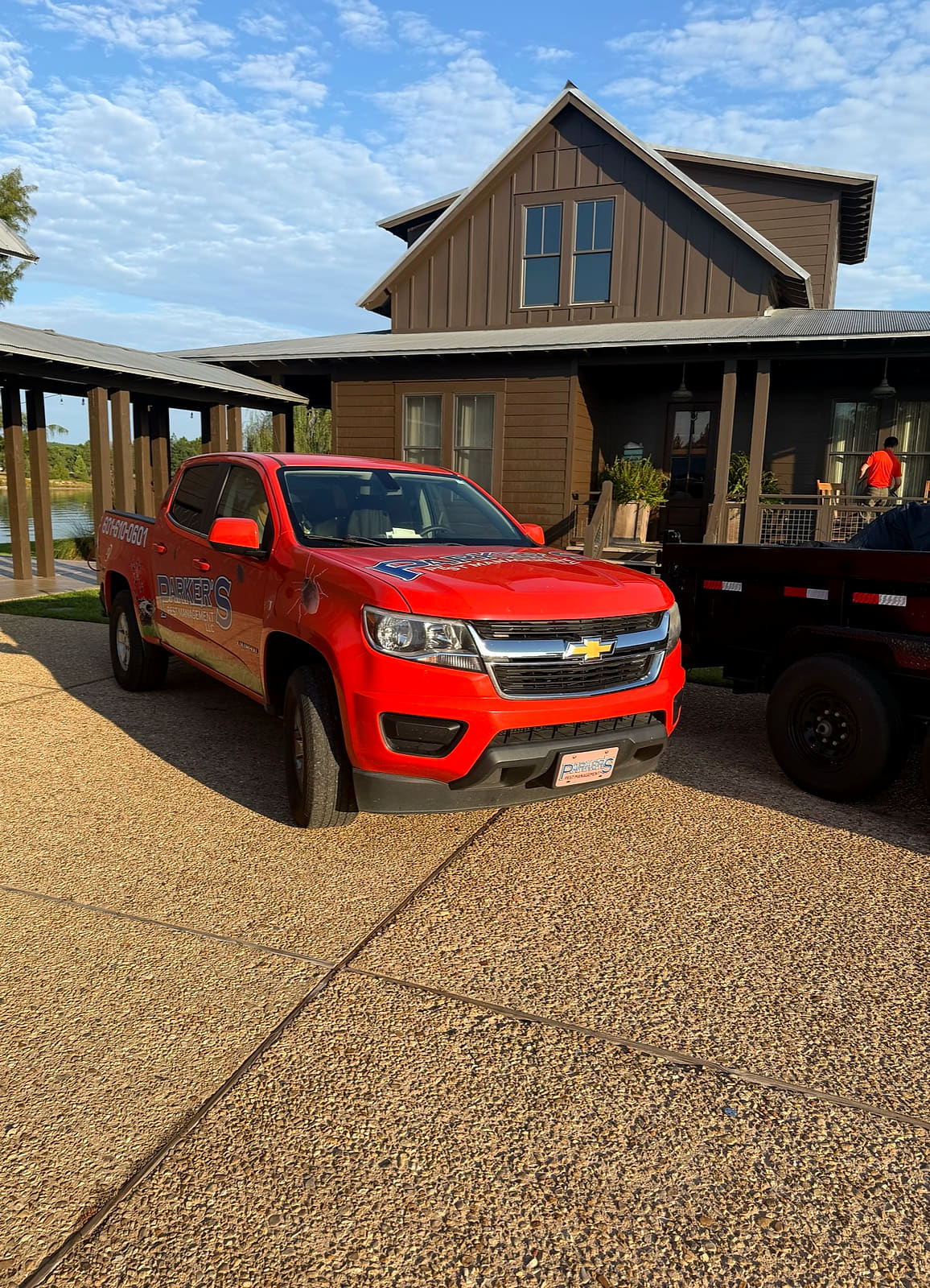 A Parker's Pest Management truck and trailer in a customer's driveway